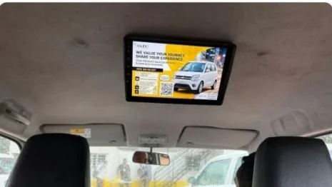 Roof-mounted screen showing an ad above the front seats of a LetzRyd car