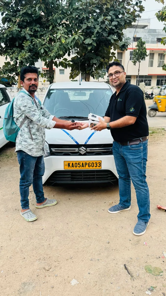 A driver-partner collecting the keys to his ribboned WagonR from a LetzRyd colleague